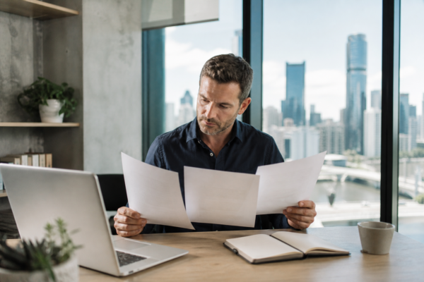 Brisbane business owner comparing SEO package proposals at an office desk